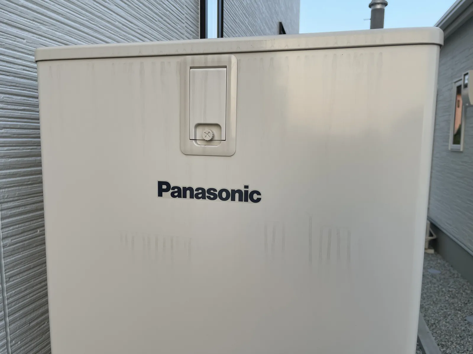 自宅の屋外に設置されたパナソニック製エコキュートの貯湯ユニット正面。Panasonicロゴと操作カバーが写る実写