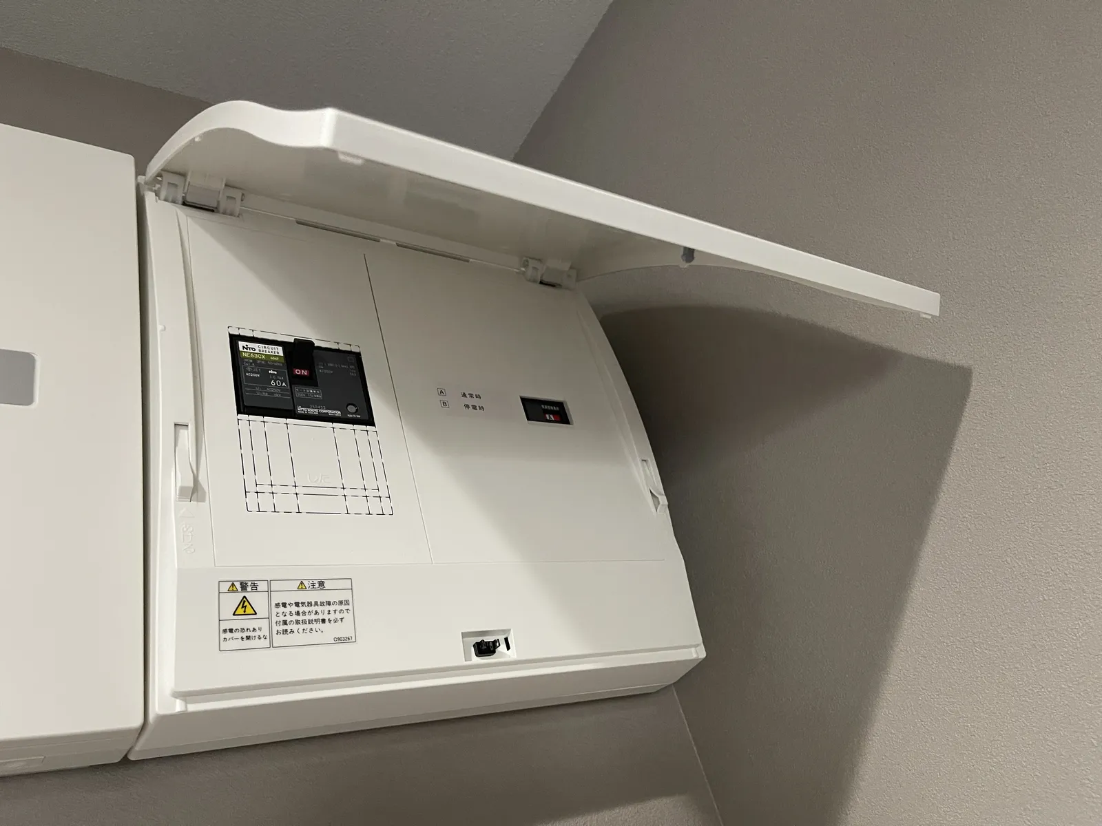 筆者宅の全負荷用切替ボックスを開けた内部。通常時と停電時の状態表示窓と配線用遮断器が見える